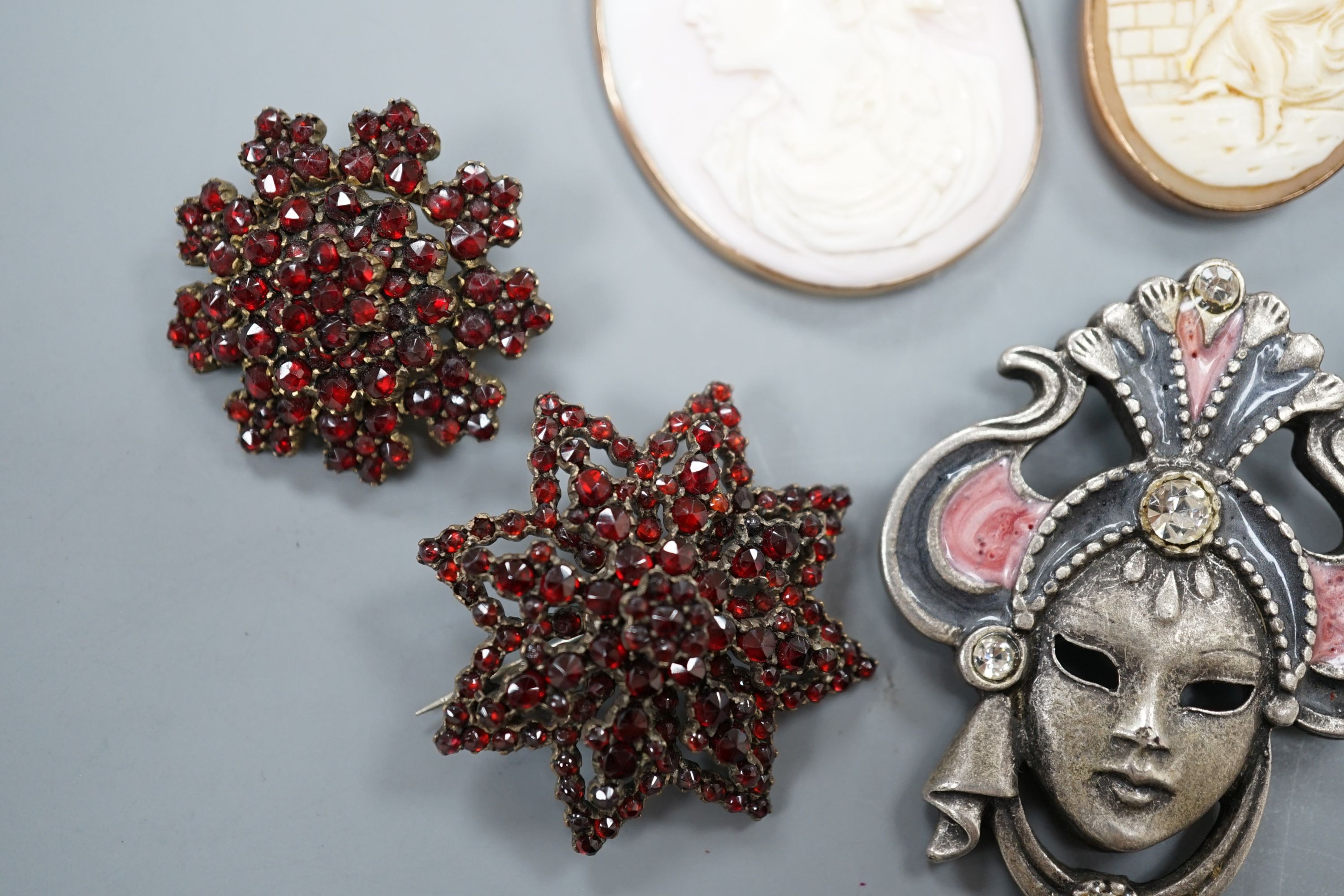 A yellow metal mounted cameo shell brooch and a similar pendant, two brooches, a white metal fob watch and one other brooch.